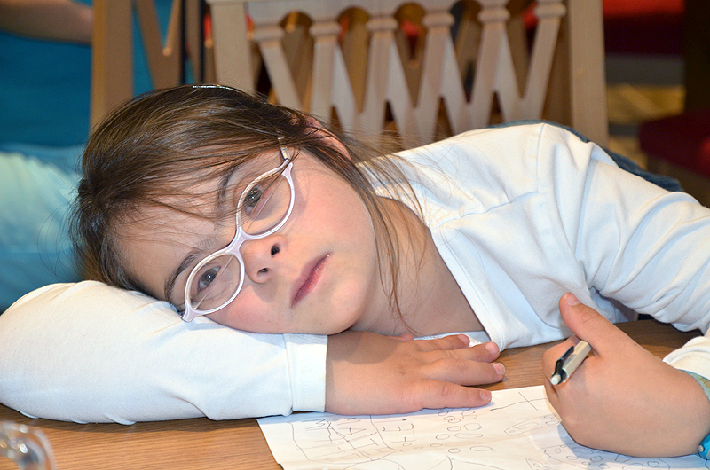 Jeune fille à lunettes, réveuse sur ses devoirs...